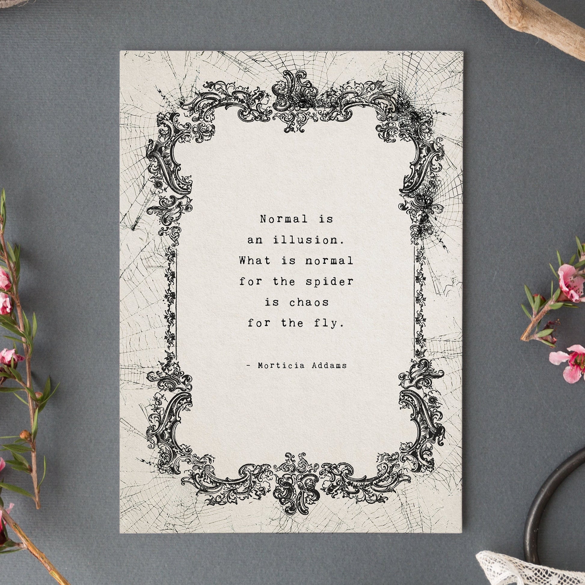 An art print featuring a black ornate frame illustration and the quote 'Normal is an illusion. What is normal for the spider is chaos for the fly." by Morticia addams