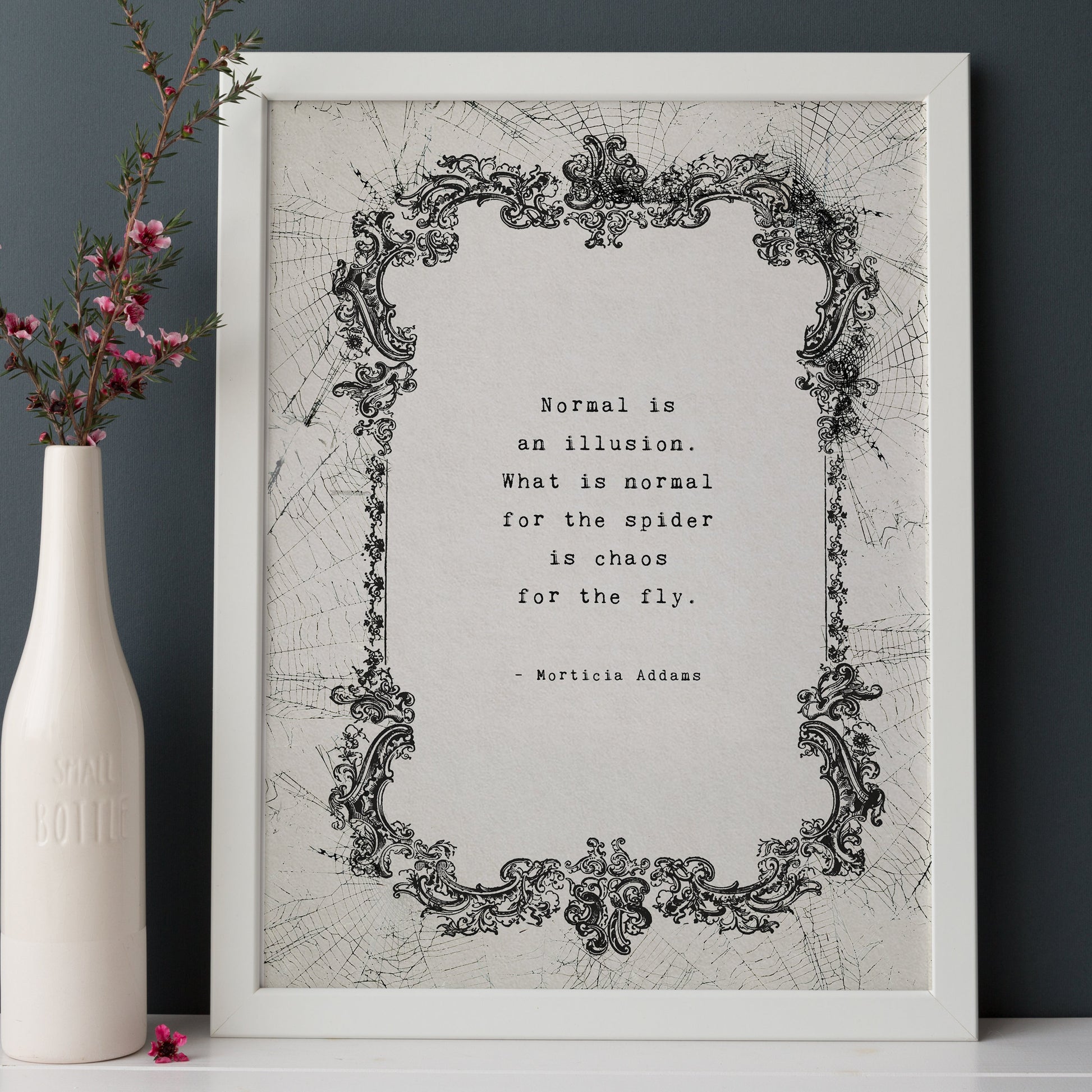 A typographic art print featuring a quote by Morticia Addams: 'Normal is an illusion. What is normal for the spider is chaos for the fly.