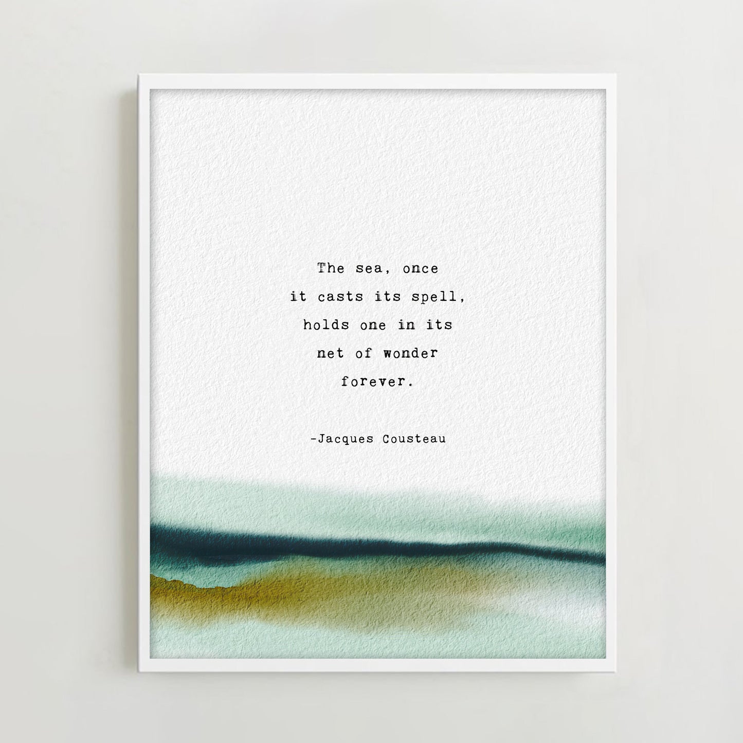 A vertical art print with a watercolor landscape at the bottom and a printed quote by Jacques Cousteau in the center, which says "the sea, once it casts it spell, holds one in its net of wonder forever"