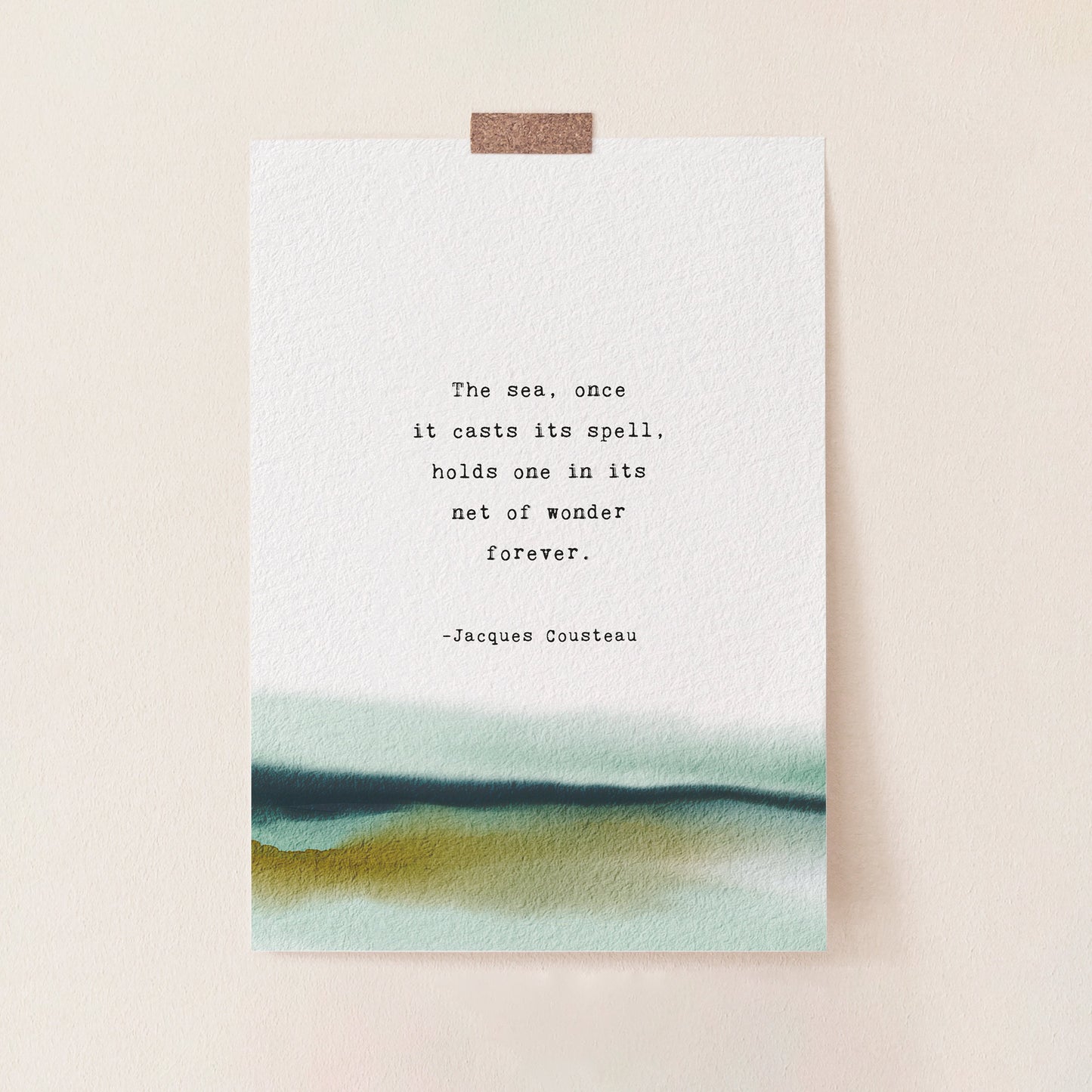 A vertical art print with a watercolor landscape at the bottom and a printed quote by Jacques Cousteau in the center, which says "the sea, once it casts it spell, holds one in its net of wonder forever"