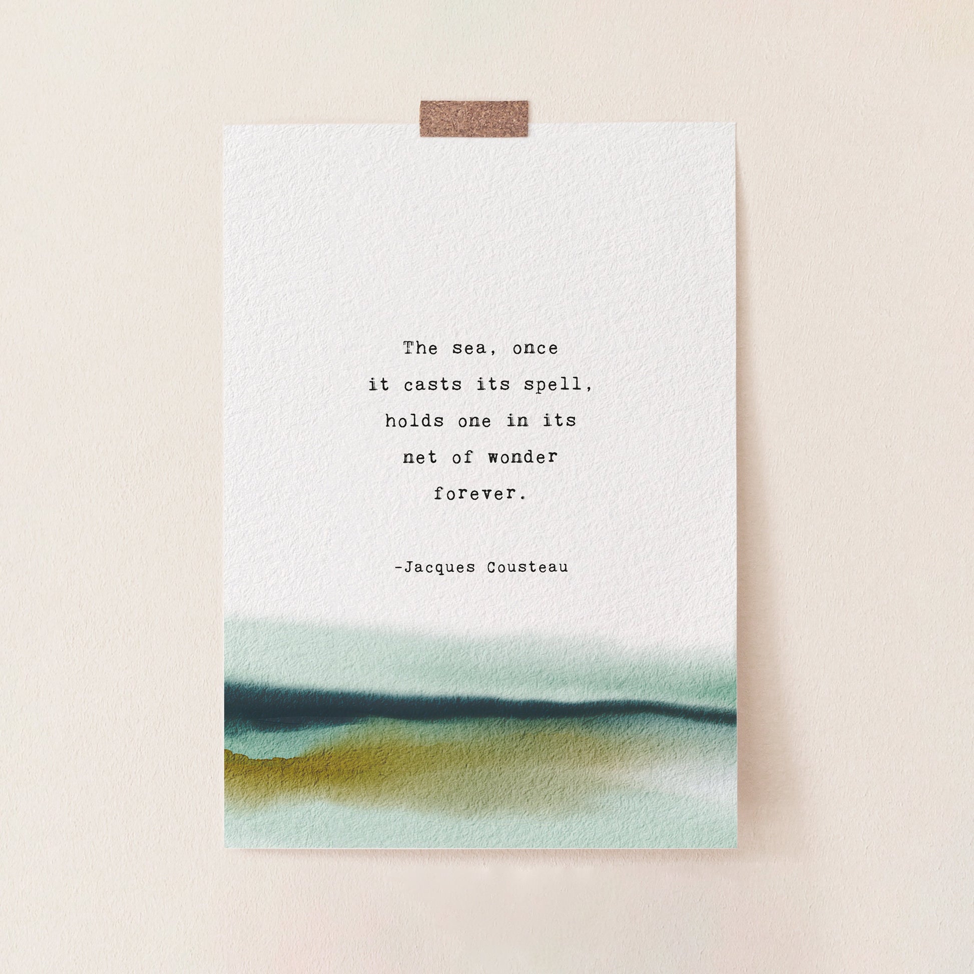 A vertical art print with a watercolor landscape at the bottom and a printed quote by Jacques Cousteau in the center, which says "the sea, once it casts it spell, holds one in its net of wonder forever"