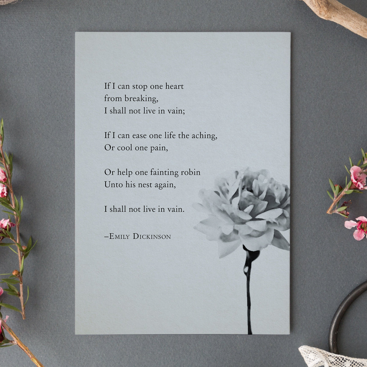 A vertical art print featuring a quote from Emily Dickinson in black text on a light gray background, with a black-and-white flower illustration in the lower right. 
