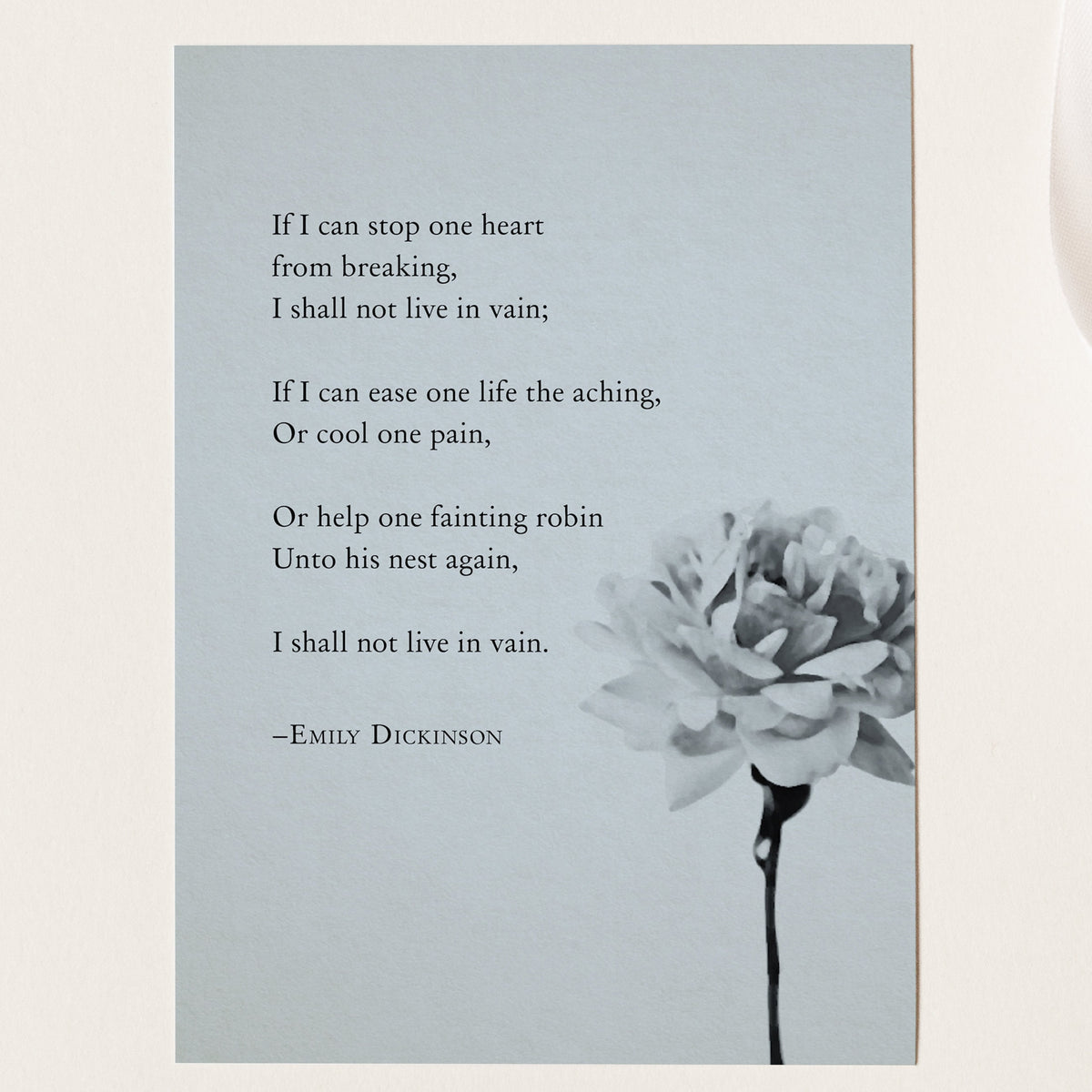 A vertical art print featuring a quote from Emily Dickinson in black text on a light gray background, with a black-and-white flower illustration in the lower right.  The quote is a poem that says "If I can stop one heart from breaking, I shall not live in vain"