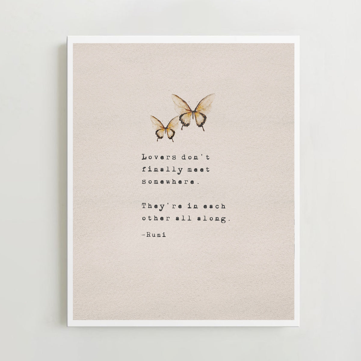 An art print featuring a quote by Rumi and two watercolor butterflies on a textured beige background with the quote "lovers don't finally meet somewhere. They're in each other all along"