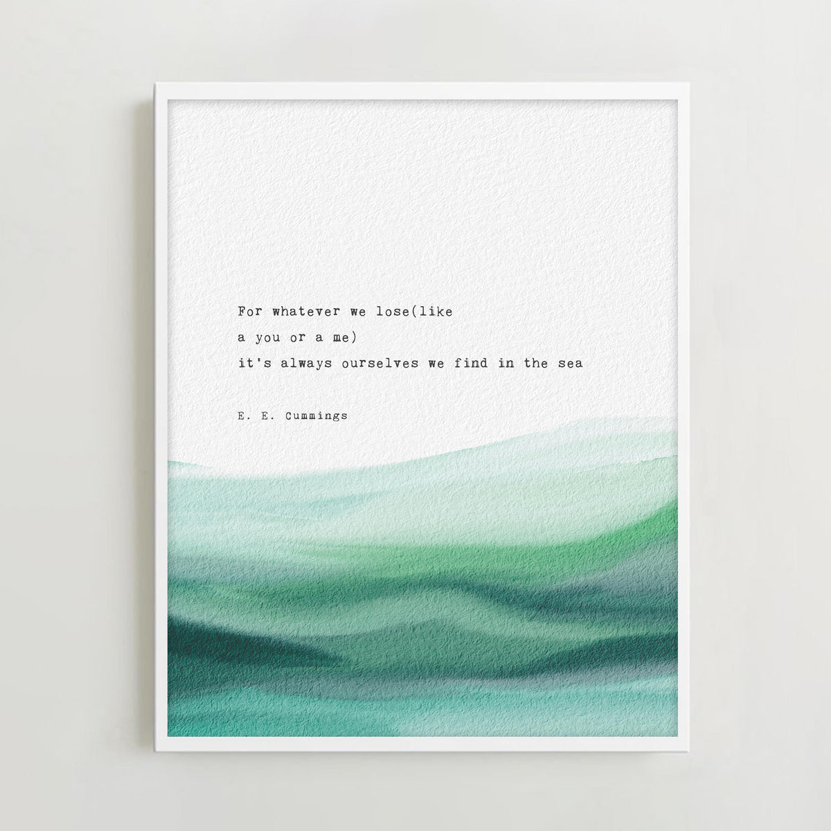 An art print featuring a quote by e.e. cummings on a soft watercolor background which says "for whatever we lose(like a you or a me) it's always ourselves we find in the sea"
