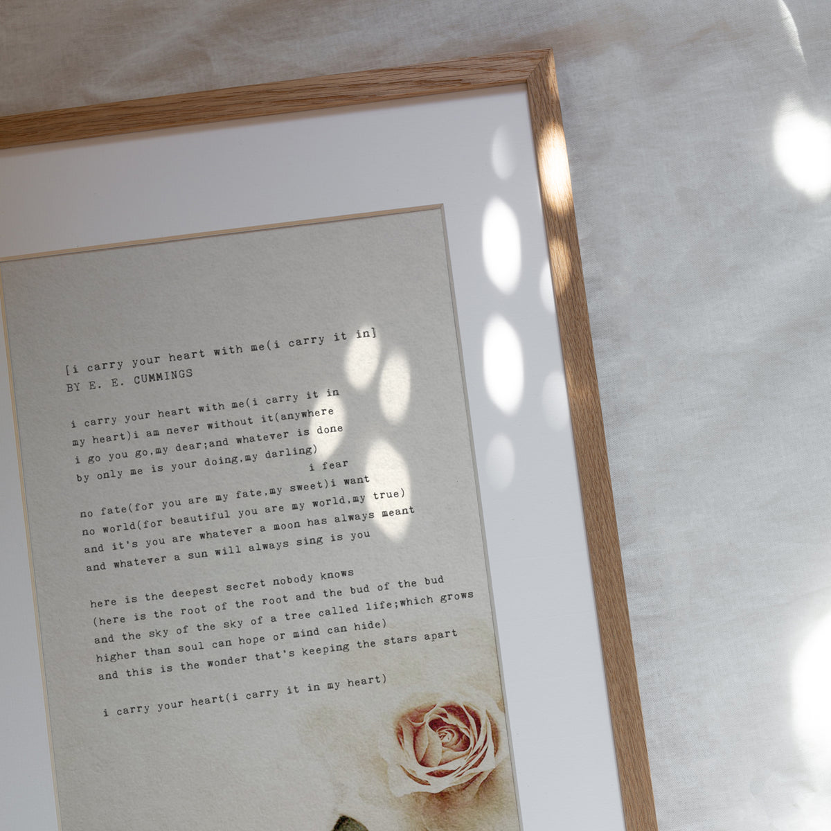 Art print of the e.e. cummings poem "I carry your hear with me" set on a biege background with a rose in the right corner
