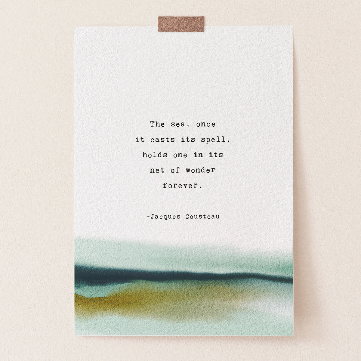 An art print featuring a quote by Jacques Cousteau on a soft watercolor background which says "the sea, once it casts its spell, holds one in its net of wonder forever"